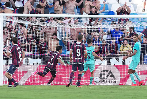 Levante's Roger Brugue, second from left, scores his side's 2nd goal during the Spanish La Liga soccer match between Levante and Barcelona in Valencia, Spain, Sunday, Sept. 13, 2026. 