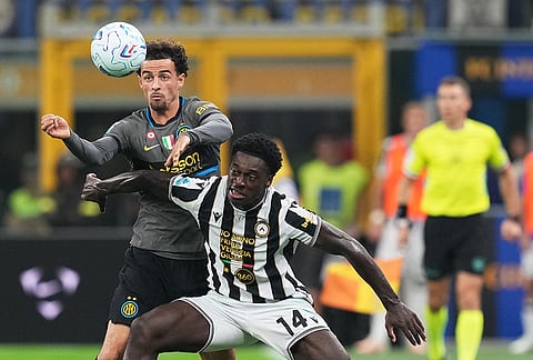 Inter Milan's Kristjan Asllani, left, challenges Udinese's James Abankwah during the Serie A soccer match between Inter Milan and Udinese in Milan, Italy, Monday, Sept. 14, 2026. 