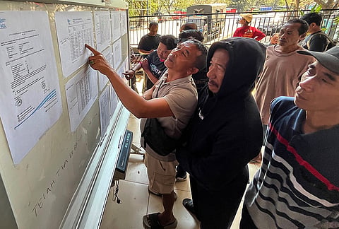 People check the passenger manifest of Virgo Transport 8 passenger ferry which overturned in bad weather in the Java Sea, at the rescuers' command center in Banjarmasin, South Kalimantan, Indonesia, Monday, Sept. 14, 2026. 