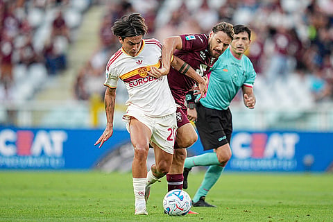 Roma's Paulo Dybala, left, and Torino's Nikola Vlasic, right, challenge for the ball during the Serie A soccer match between FC Torino and AS Roma in Turin, Italy.