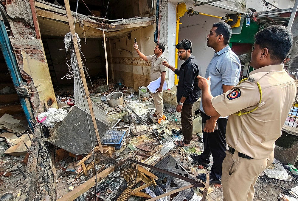 Police and administrative officials inspect the site after a commercial gas cylinder blast at an eatery damaged six shops and injured two workers, in Sanpada, Navi Mumbai, Maharashtra. - | Photo: PTI