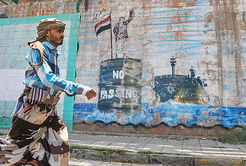 A man walks in front of a mural symbolising restrictions on shipping through the Bab el-Mandeb Strait, one of the world's key shipping lanes, in Sanaa, Yemen, Monday, Sept. 14, 2026. 