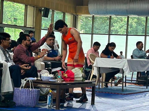 A wrestler seeks Brij Bhushan Sharan Singh's blessings after winning a bout.