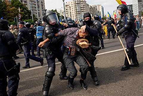 A demonstrator is detained following scuffles with riot police during a farmers' protest in Bucharest, Romania, Tuesday, Sept. 15, 2026. 