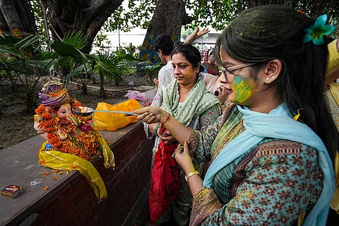 People prepare to immerse an idol of Lord Ganesh in a canal during the 'Ganesh Chaturthi' festival, on the outskirts of Amritsar, Punjab.