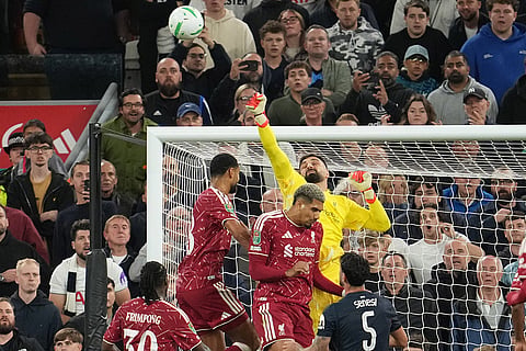 Liverpool's goalkeeper Giorgi Mamardashvili punches the ball during the third-round English Football League soccer match between Liverpool and Tottenham in Liverpool, England.