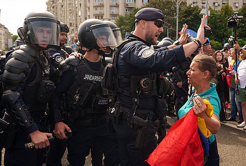 Riot police stop a woman holding a Romanian flag during a farmers' protest in Bucharest, Romania, Tuesday, Sept. 15, 2026. 
