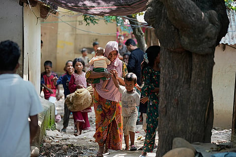 Rohingya refugees hold their children following government notices ordering the removal of unauthorized structures in Jammu, India.