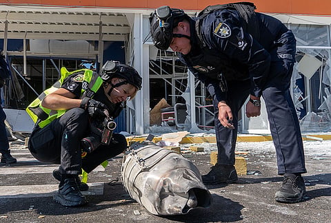 Police officers inspect fragments of a Russian drone after an air attack on a commercial infrastructure in Kharkiv, Ukraine, Thursday, Sept. 17, 2026. 