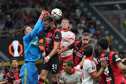 Benfica's goalkeeper Anatoliy Trubin saves on an header by AC Milan's Strahinja Pavlovic during the Europa League opening phase soccer match between AC Milan and Benfica in Milan, Italy.
