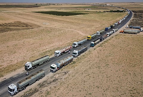 Oil tankers from the Rmeilan oil fields are backed up along a road after being stopped by local residents during ongoing protests against higher fuel prices near Tal Tamr in northeastern Syria, Wednesday, Sept. 16, 2026. 