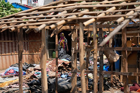 A Rohingya refugee woman looks at her household belongings as her family prepares to leave their rented home following government notices ordering the removal of unauthorized structures in Jammu, India.