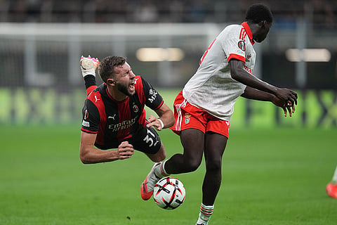 AC Milan's Strahinja Pavlovic is tackled by Benfica's Daniel Banjaqui during the Europa League opening phase soccer match between AC Milan and Benfica in Milan, Italy.