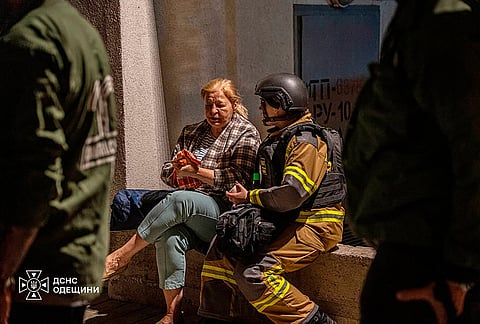A firefighter, right, comforts a woman after her home was damaged in a Russian air attack in Odesa, Ukraine, Thursday, Sept. 17, 2026. 