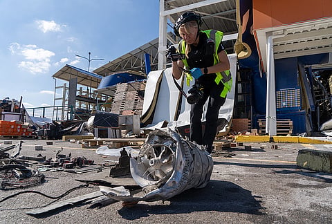 A police officer inspects fragments of a Russian drone after an air attack on a commercial infrastructure in Kharkiv, Ukraine, Thursday, Sept. 17, 2026. 