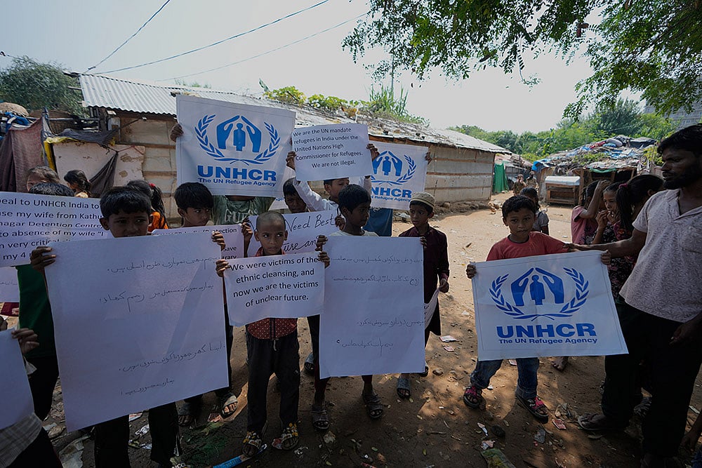 Rohingya refugee children hold placards appealing to the UNHCR (United Nations High Commissioner for Refugees) for help following government notices ordering the removal of unauthorized structures in Jammu, India. - | Photo: AP/Channi Anand
