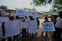 In Photos: Rohingya Eviction Drive Carried Out In Jammu | Photo: AP/Channi Anand : Rohingya refugee children hold placards appealing to the UNHCR (United Nations High Commissioner for Refugees) for help following government notices ordering the removal of unauthorized structures in Jammu, India.