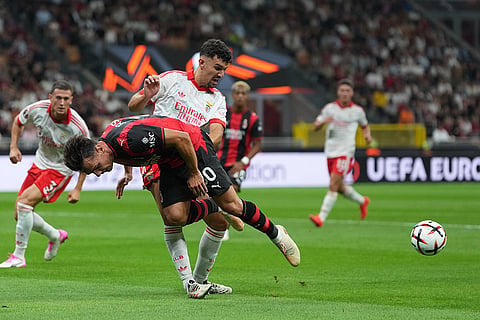 AC Milan's Ardon Jashari is tackled by Benfica's Tomas Araujo during the Europa League opening phase soccer match between AC Milan and Benfica in Milan, Italy.