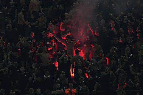 AC Milan fans cheer during the Europa League opening phase soccer match between AC Milan and Benfica in Milan, Italy.