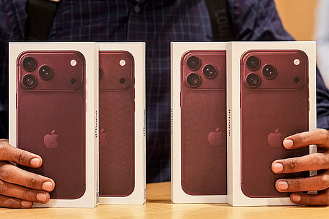 A customer displays the latest iPhone 18 series at an Apple store during its official sales launch, in Bengaluru, Karnataka.
