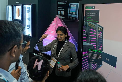 An exhibitor explains chips used for mass storage to delegates at an exhibition showcasing semiconductor technologies at Semicon India 2026 in New Delhi, India, Friday, Sept. 18, 2026. 