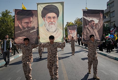 Uniformed participants carry a portrait of Iran's Supreme Leader Mojtaba Khamenei, left, and three portraits of his late father and predecessor, Ali Khamenei, during the state-organized "Janfada," or "Sacrifice for Iran," military-style parade in Tehran, Iran, Friday, Sept. 18, 2026. 