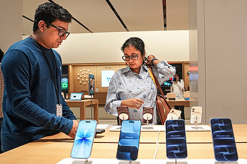 A staff assists a customer at an Apple store during the official sales launch of the iPhone 18 Pro and iPhone 18 Pro Max, in Bengaluru, Karnataka.