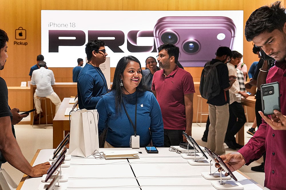 A staff assists a customer at an Apple store during the official sales launch of the iPhone 18 Pro and iPhone 18 Pro Max, in Bengaluru, Karnataka. - | Photo: PTI/Shailendra Bhojak