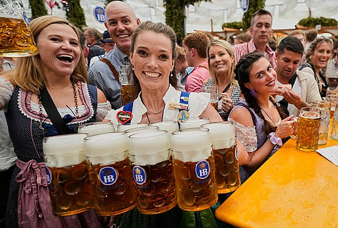 Waitress carriy beer mugs after the opening of the 191st Oktoberfest beer festival in Munich, Germany, Saturday, Sept.19, 2026. 