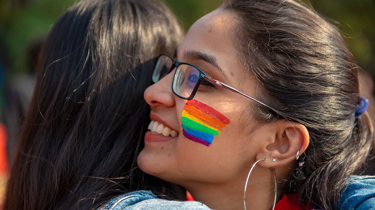 A lesbian couple participates in a pride parade - Shutterstock