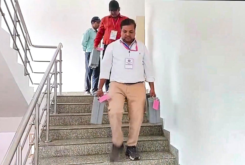 Election personnel carry EVMs kept in secured containers amid security arrangements during the counting of votes for the Delhi University Students Union (DUSU) elections 2026-2027 at the Delhi University North Campus Sports Stadium, in New Delhi, Saturday, Sept. 19, 2026. 
