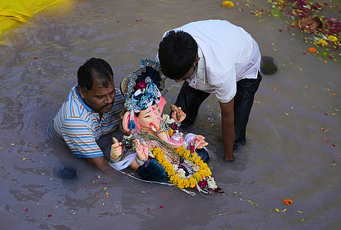 Devotees immerse an idol of the elephant-headed Hindu god Ganesha in an artificial pond on the fifth day of the ten-day long Ganesh Chaturthi festival in Ahmedabad, Friday, Sept. 18, 2026. 
