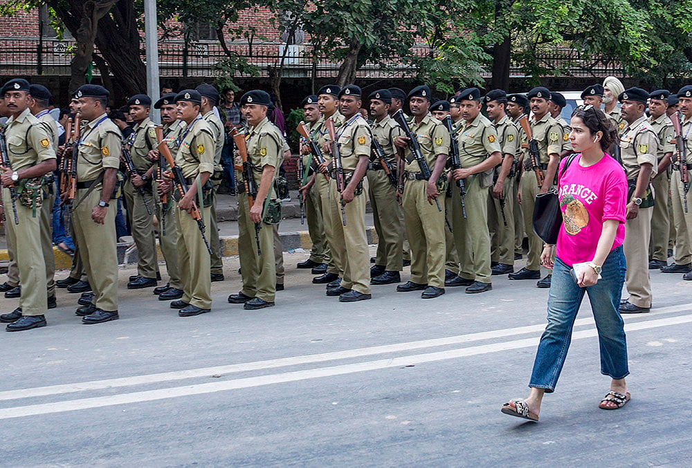 A student passes by as security officials keep vigil during the ongoing counting for the Delhi University Students Union (DUSU) elections, in New Delhi, Saturday, Sept. 19, 2026. 
