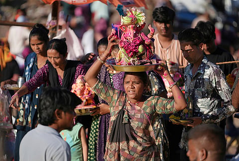 A devotee carries an idol of the elephant-headed Hindu god Ganesha on her head for immersion in an artificial pond on the fifth day of the ten-day long Ganesh Chaturthi festival in Ahmedabad, Friday, Sept. 18, 2026.
