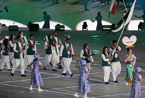 Pakistan's flag bearers Fatima Sana Khan and Noor Zaman and athletes react as they walk into the stadium during the opening ceremony for the Asian Games in Nagoya, Japan, Saturday, Sept. 19, 2026. 