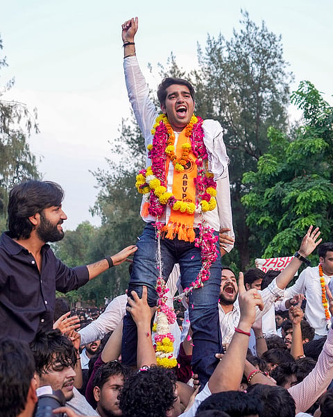 Akhil Bharatiya Vidyarthi Parishad's (ABVP) Yash Dabas, garlanded, celebrates with others after winning the president's post in the Delhi University Students' Union (DUSU) elections, at North Campus, in New Delhi, Saturday, Sept. 19, 2026. 