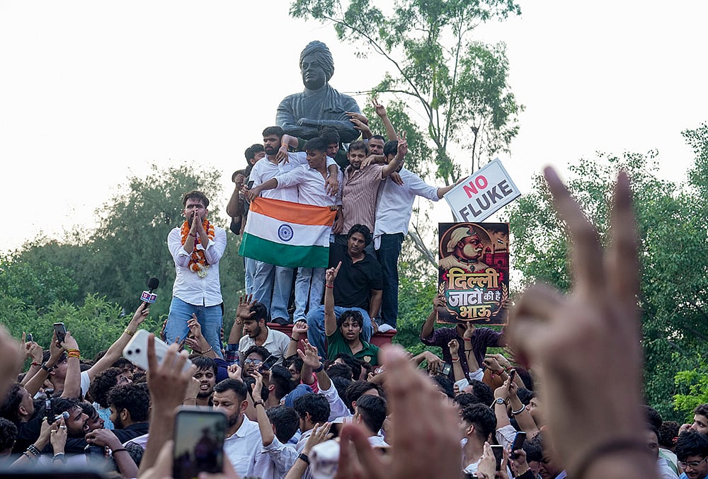 Independent candidate Deepanshu Shokeen, garlanded, celebrates with others atop Swami Vivekanands statue after winning the vice-presidents post in the Delhi University Students Union (DUSU) elections, at North Campus, in New Delhi, Saturday, Sept. 19, 2026. 