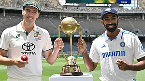 X/mufaddal_vohra : Pat Cummins (left) of Australia posing with the Border-Gavaskar Trophy alongside interim Test captain Jasprit Bumrah of India.