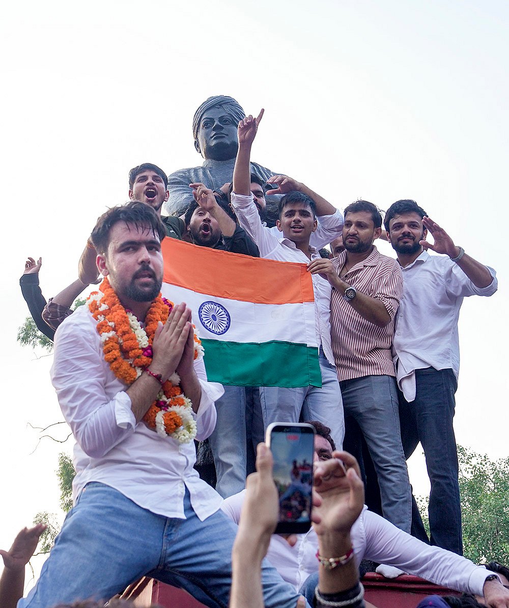Independent candidate Deepanshu Shokeen, garlanded, celebrates with others atop Swami Vivekanands statue after winning the vice-presidents post in the Delhi University Students Union (DUSU) elections, at North Campus, in New Delhi, Saturday, Sept. 19, 2026. 

