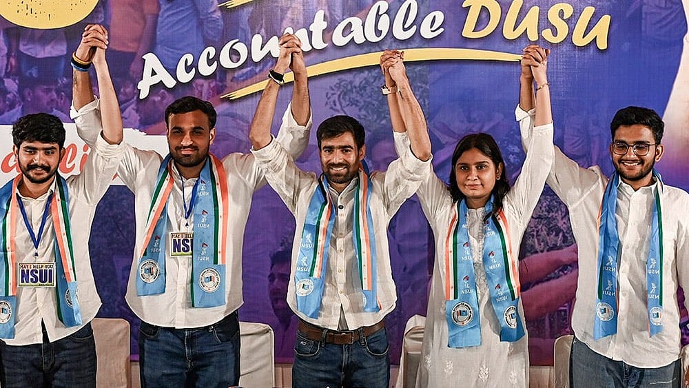 NSUI National President Vinod Jakhar, centre, holds hands with party candidates for the Delhi University Students' Union (DUSU) elections 2026-27 (L-R) Gopal Chaudhary (Joint Secretary), Vir Chatrath (Vice President), Namrata Chaudhary (Secretary), and Vijay Shankar Meena (President) during a press conference, in New Delhi. - Photo: PTI