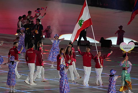 Lebanon's flag bearers Maria Chedid and Michael Antoine Yared and athletes react as they walk into the stadium during the opening ceremony for the Asian Games in Nagoya, Japan, Saturday, Sept. 19, 2026. 