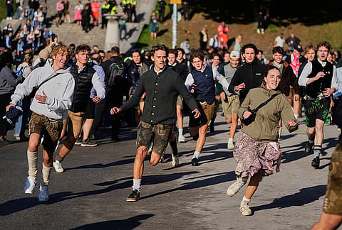 People run to enter the 191st Oktoberfest beer festival in Munich, Germany, Saturday, Sept.19, 2026. 
