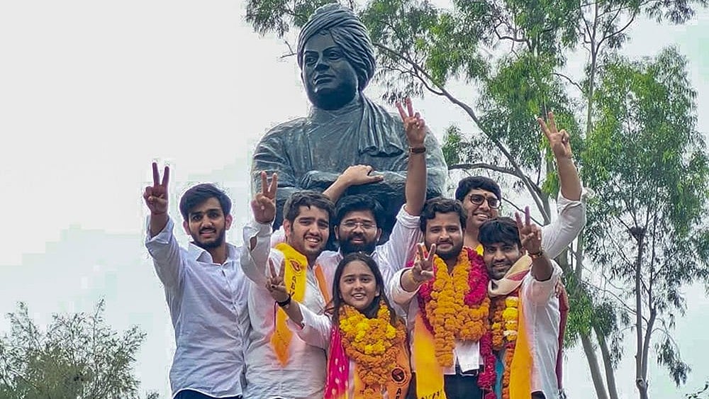 Akhil Bharatiya Vidyarthi Parishad's (ABVP) Yash Dabas and others celebrate after winning three of the four central panel posts in the Delhi University Students' Union (DUSU) elections, at North Campus, in New Delhi.  - | Photo: @ABVPVoice/X via PTI 