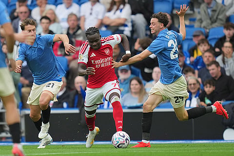 Arsenal's Bukayo Saka in action between Brighton's Olivier Boscagli, left, and Maxim De Cuyper during the English Premier League soccer match between Brighton & Hove Albion and Arsenal in Brighton, England.