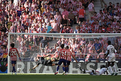 Real Madrid's Antonio Rudiger, on the ground, scores his side's first goal past Atletico Madrid's goalkeeper Jan Oblak during a Spanish La Liga soccer match between Atletico Madrid and Real Madrid in Madrid, Sunday, Sept. 20, 2026. 