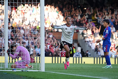 Fulham's Josh King, center, celebrates after Manchester United's Lisandro Martinez, right, scores an own goal past his goalkeeper during the English Premier League soccer match between Fulham and Manchester United in London.