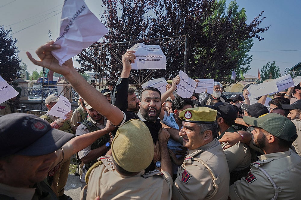A supporter of the Jammu Kashmir Apni Party shouts slogans against the ruling government as police officers try to stop him during a protest demanding jobs, opposing a power tariff hike and pressing other demands in Srinagar, Kashmir. - | Photo: AP/Mukhtar Khan