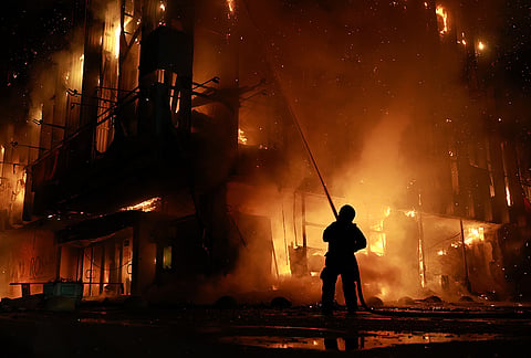 A rescue worker puts out a fire at the Intrade trade center after a Russian drone strike on Zaporizhzhia, Ukraine, Monday, Sept. 21, 2026. 