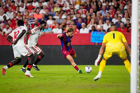 Barcelona's Fermin Lopez, centre, shoots the ball during the Spanish La Liga soccer match between Sevilla and Barcelona in Seville, Spain.