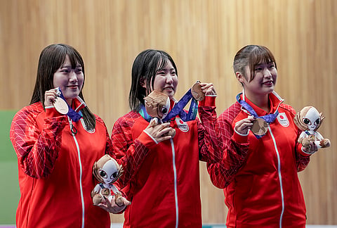 From left, Japan's Misaki Nobata, Hinata Taichi and Shiori Hirata pose for photographers after winning bronze medals in the 10m Air Rifle Women Team Final event during the 20th Asian Games, in Nagoya, Japan, Sunday, Sept. 20, 2026. 